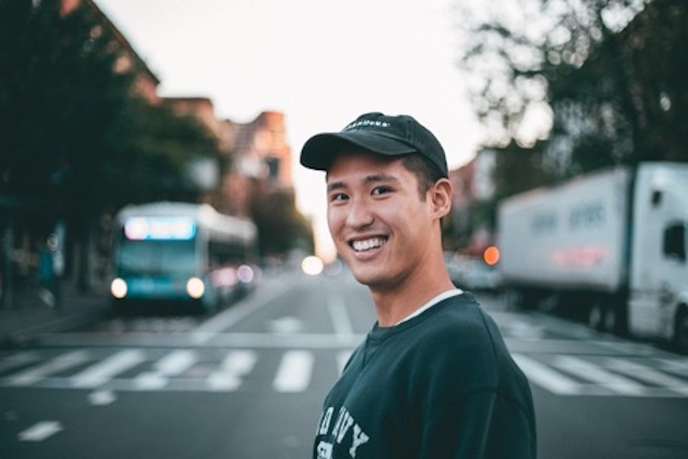 student smiling set against a blurred street background