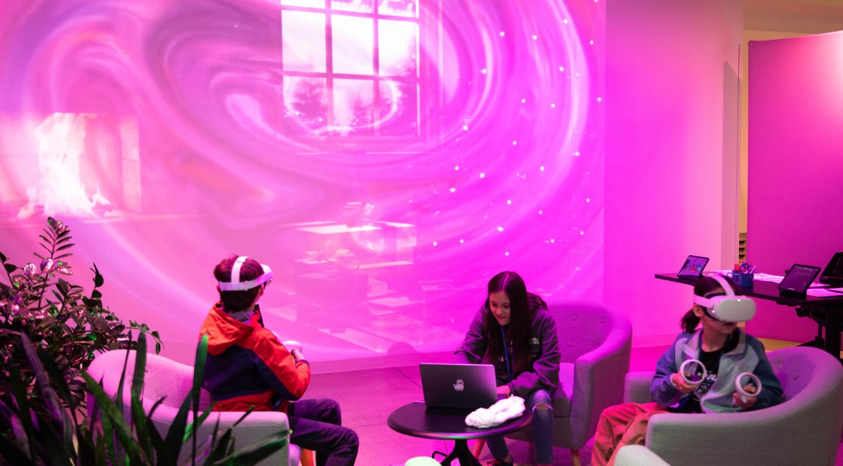 Two students sit in the Smith Learning Theater using VR headsets