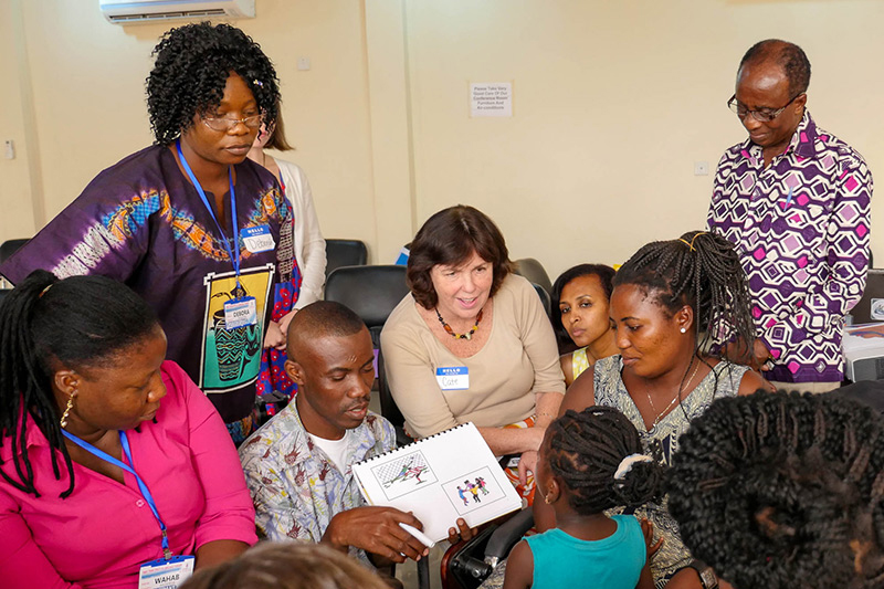 HOUSE CALL Professor Cate Crowley (center, in white) and students from TC's Program in Communication Sciences & Disorders conduct speech therapy for cleft palate patients in Ghana.