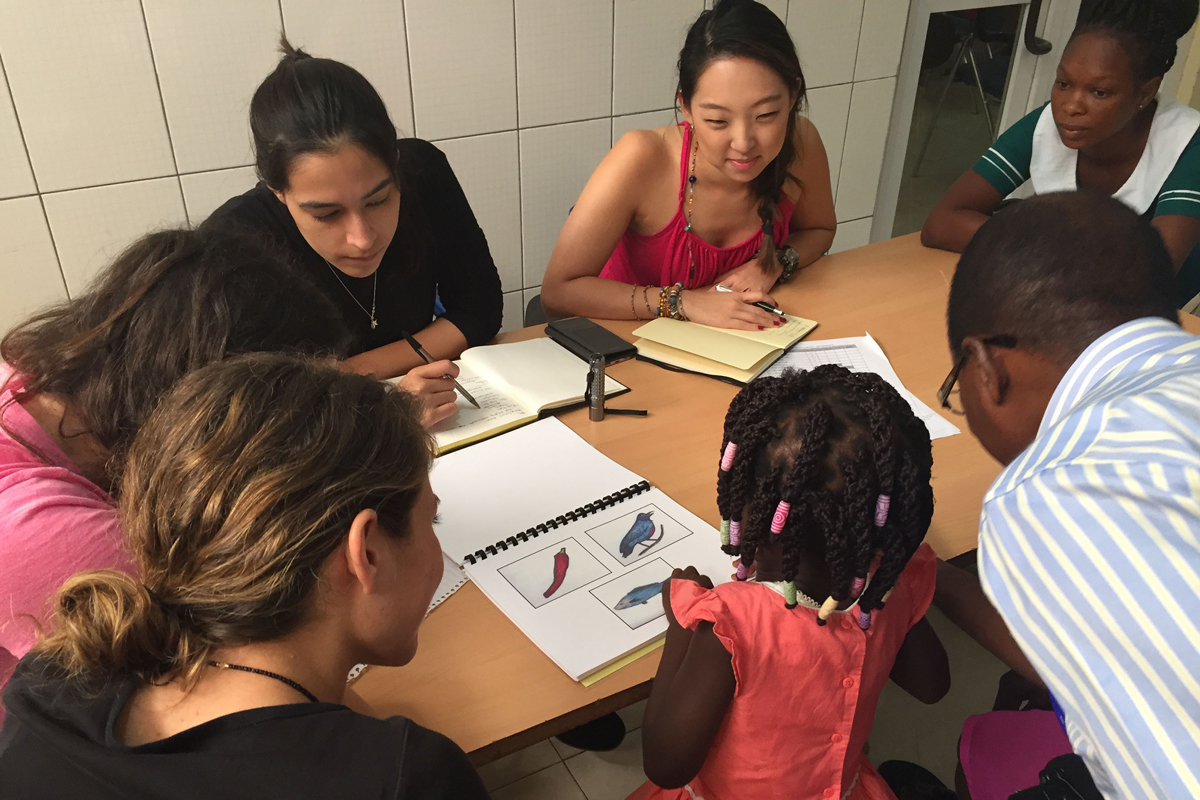Grad students working with a child on language tasks
