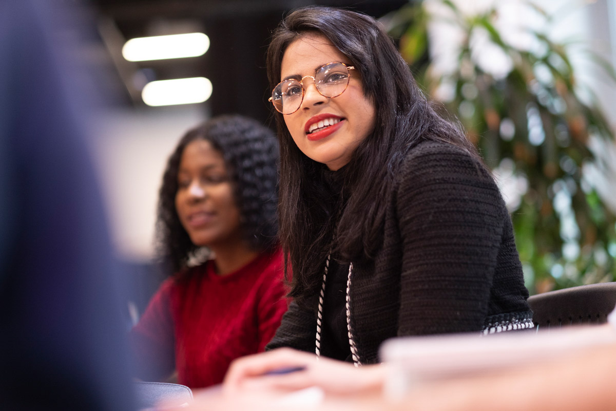 A graduate student listens to a student in her cohort.