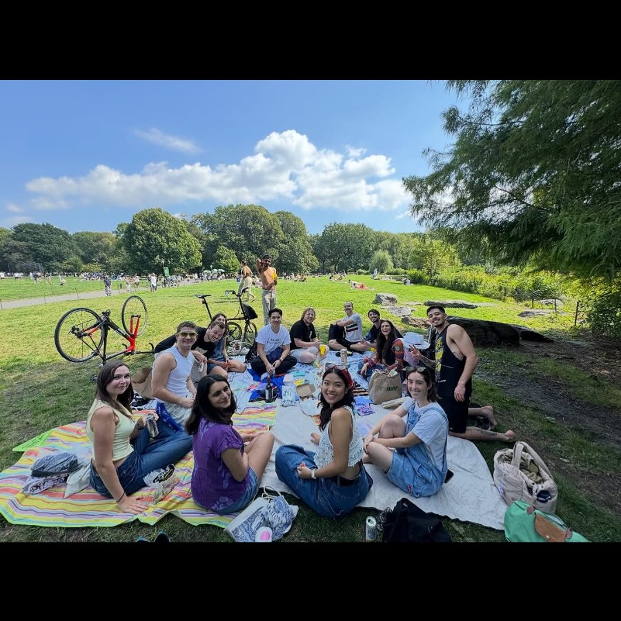 A group of students sitting on picnic blankets in the park.