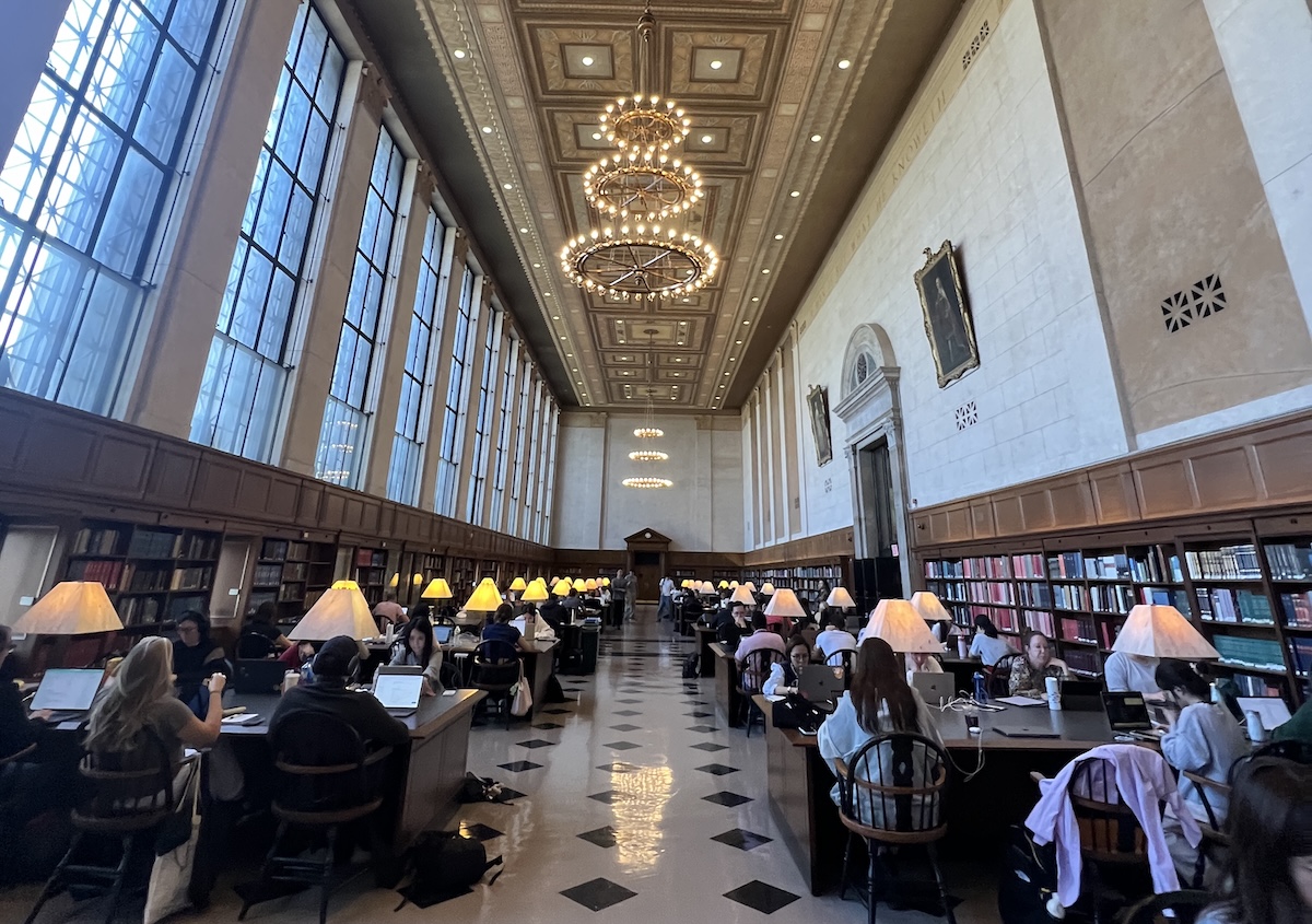 Reading room at Butler Library with students studying at tables.