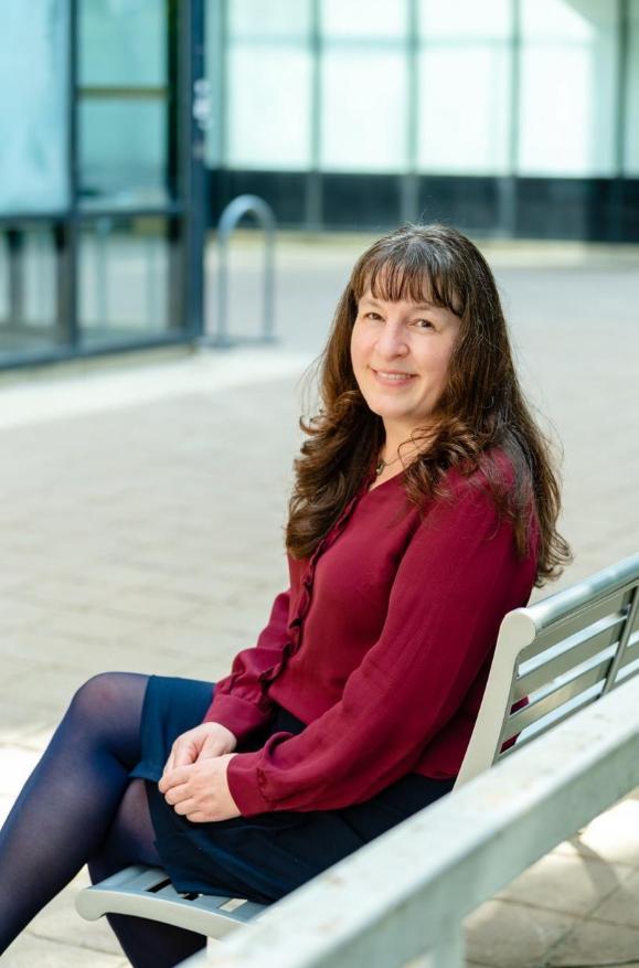 Picture of Dr. Rachel Talber sitting on bench smiling.