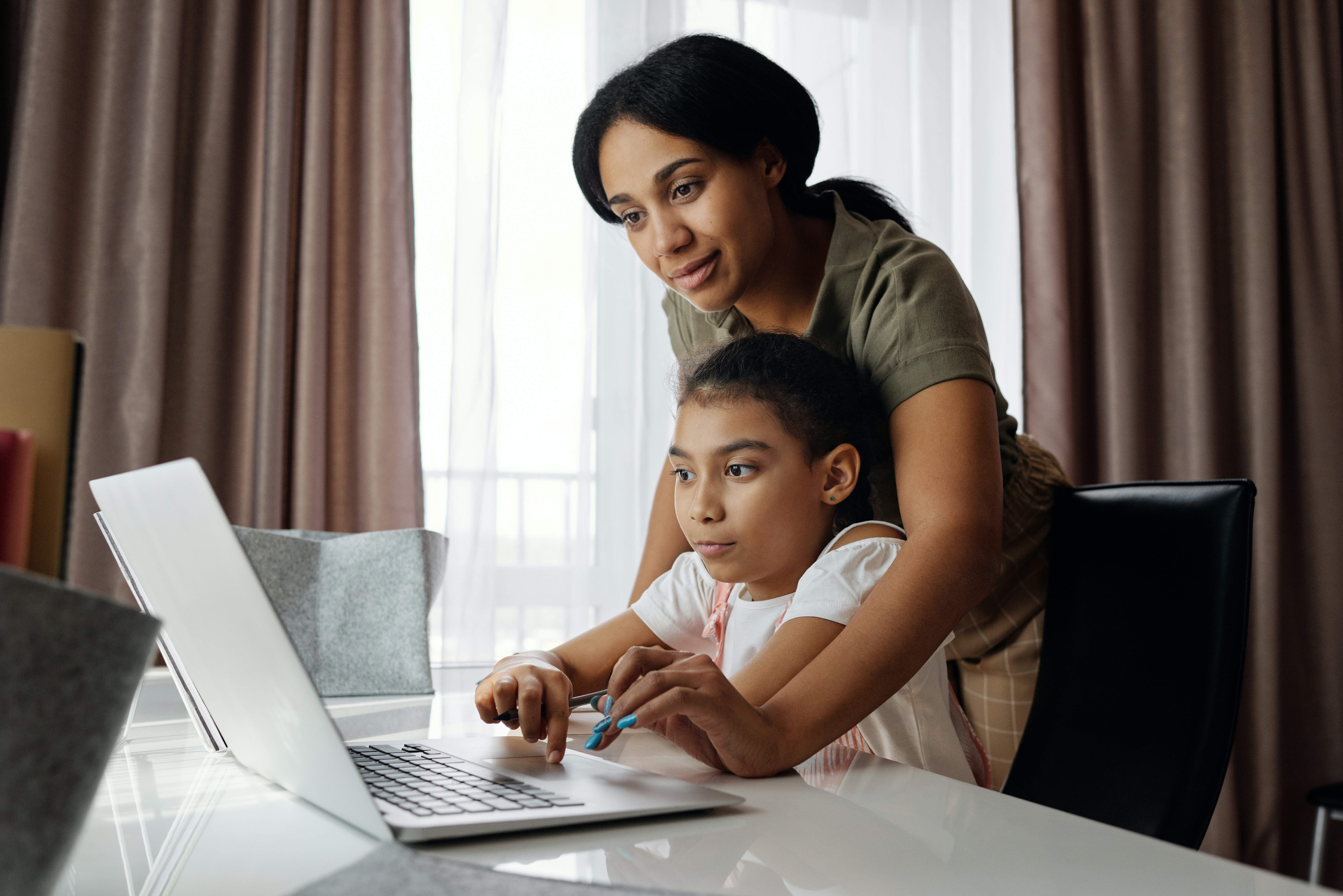 child and adult working on the computer