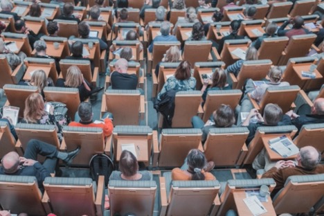 Rows of students in lecture hall style seating