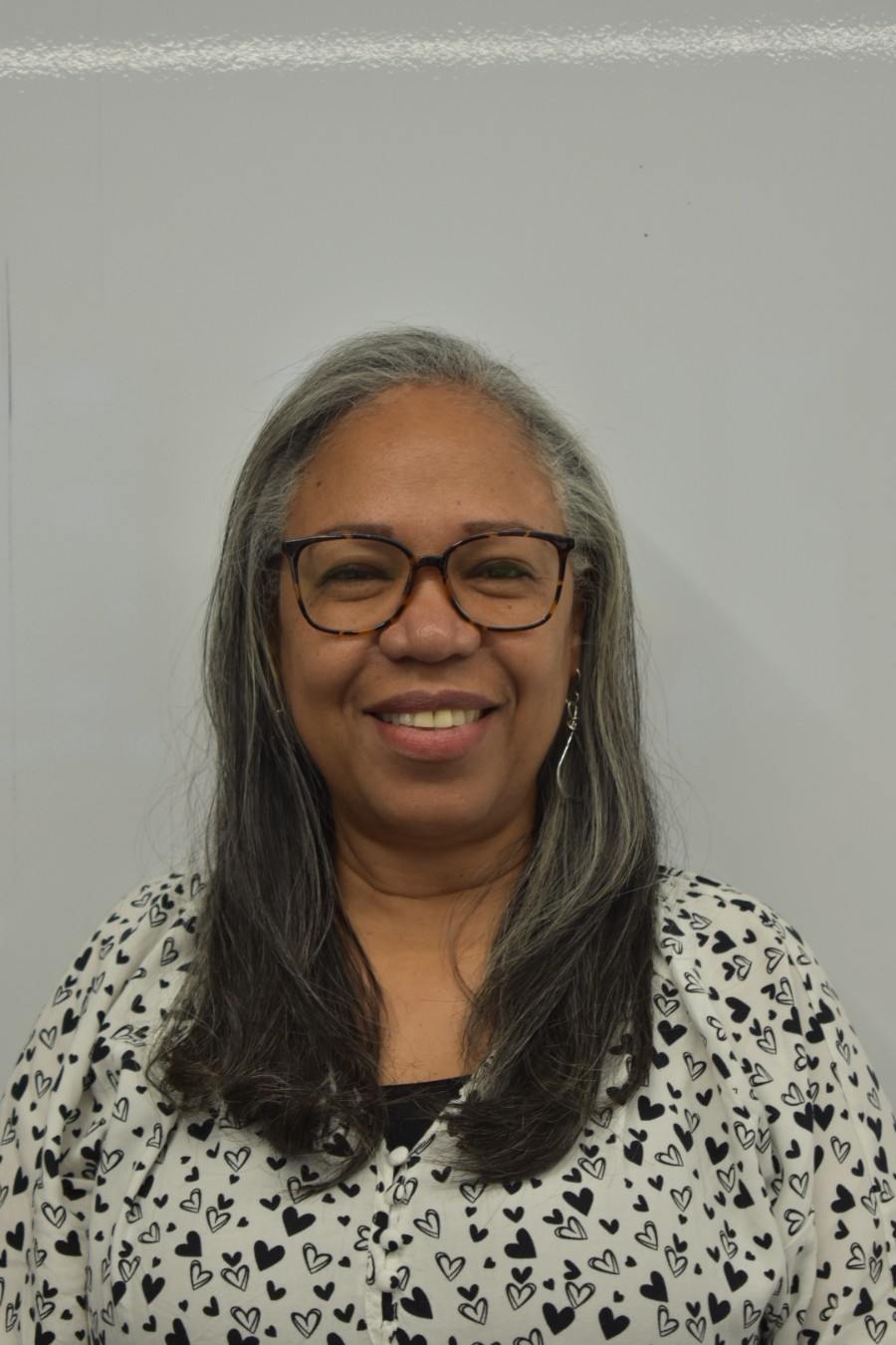 A person smiling against a white backdrop.