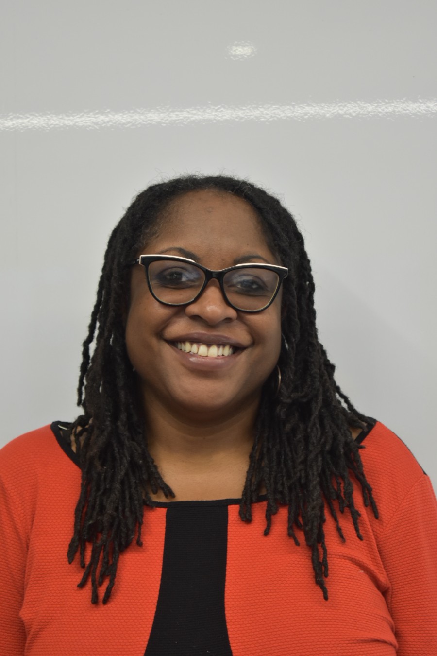 A person smiling against a white backdrop.