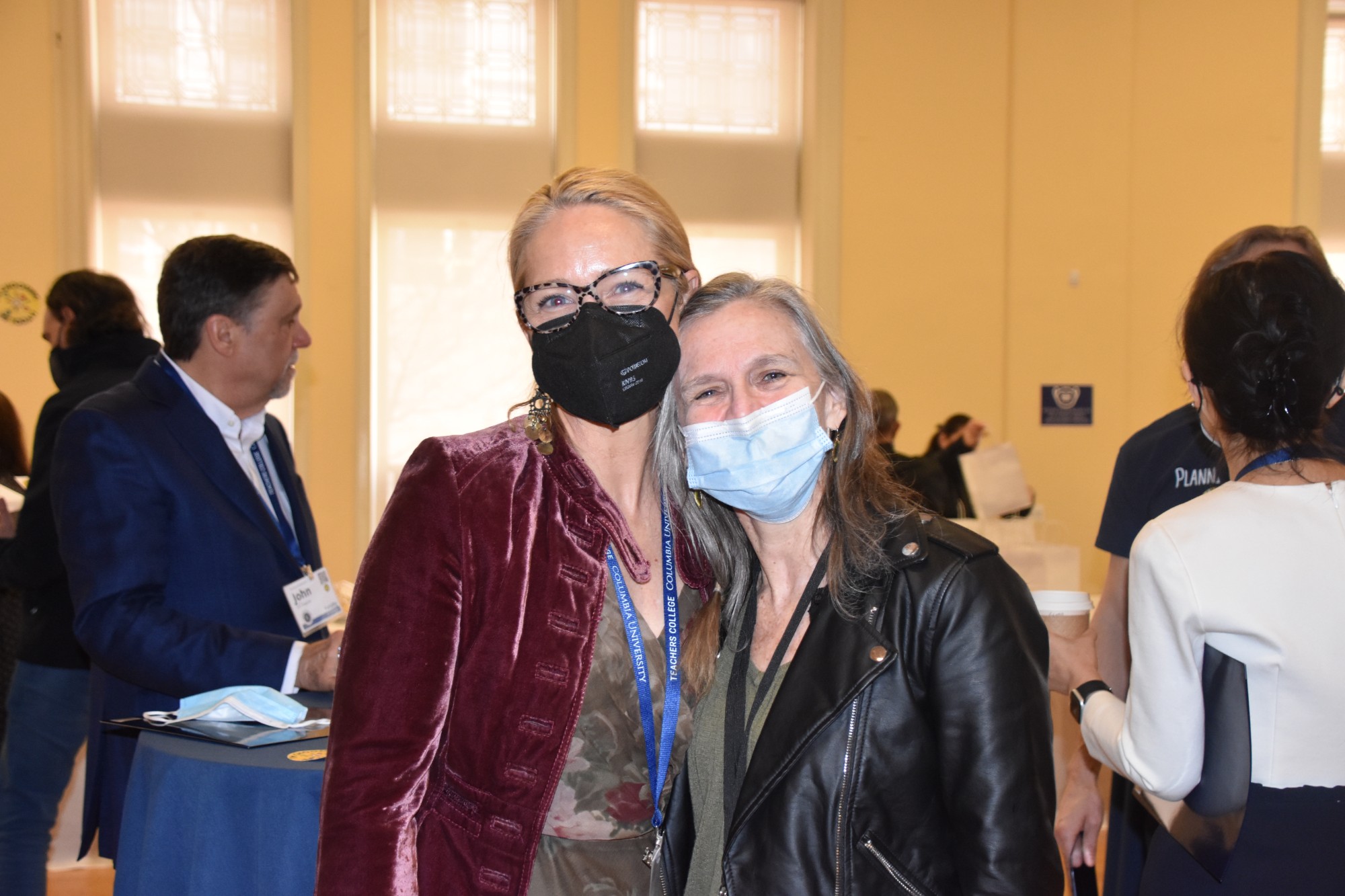 Two masked but visibly happy people embracing one another. 