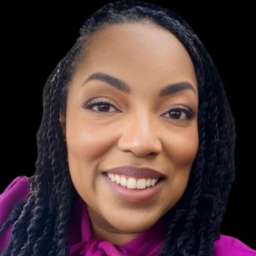 A headshot of Meryl. She is a Black woman with dark, braided hair pulled back from her face. She is smiling broadly, showing her teeth, and looking directly at the viewer. She has warm brown eyes and her makeup is natural. She is wearing a deep magenta top with a tie detail at the neck. The background is solid black, emphasizing her face.