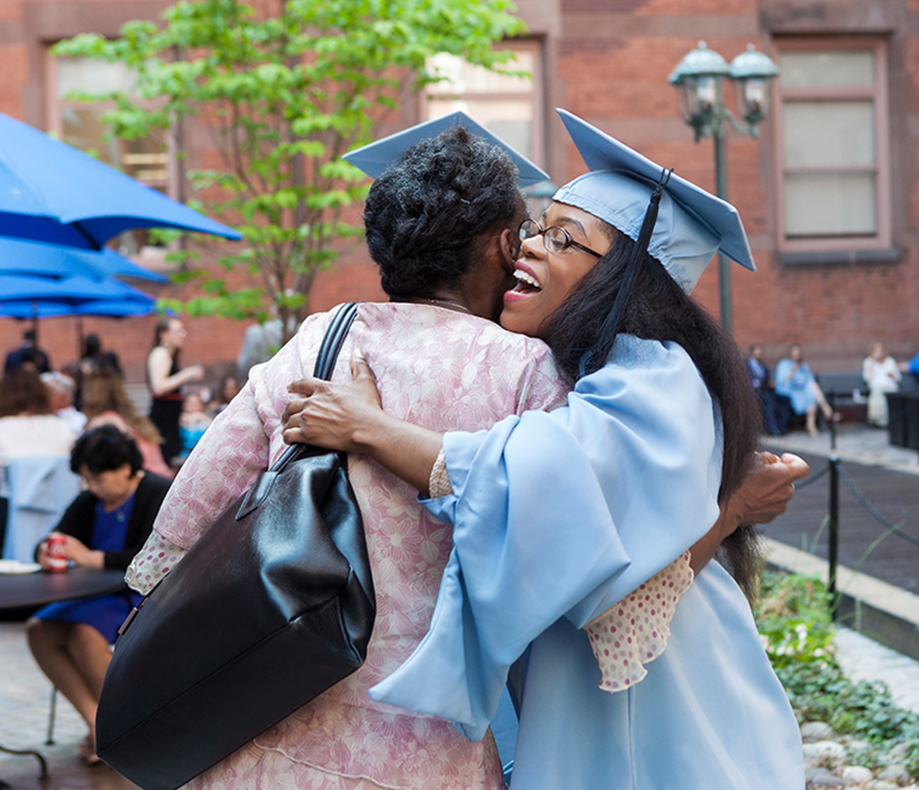 A student hugs a parent on graduation day