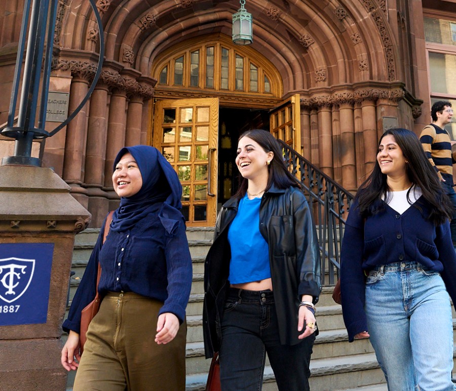 Graduate students walking down stairs after exiting a building