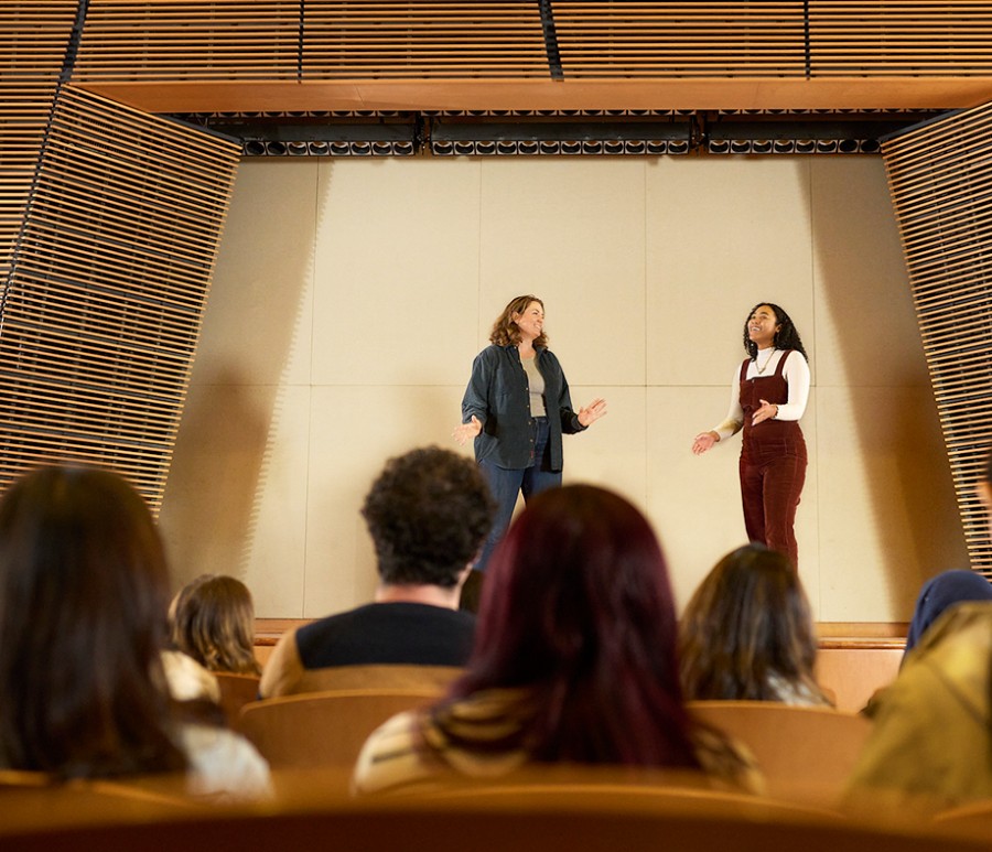Two students on stage in front of an audience