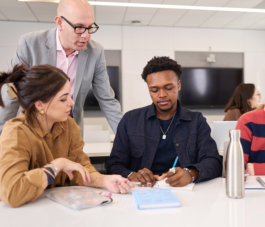 Two students getting feedback from a professor