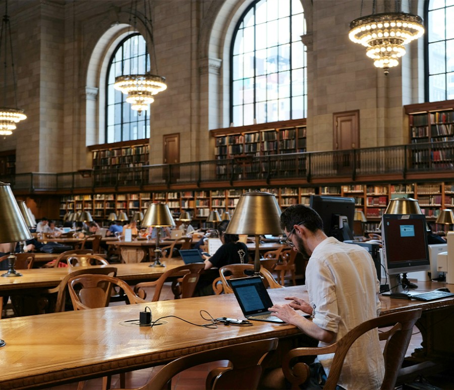 A person working on a laptop in a library