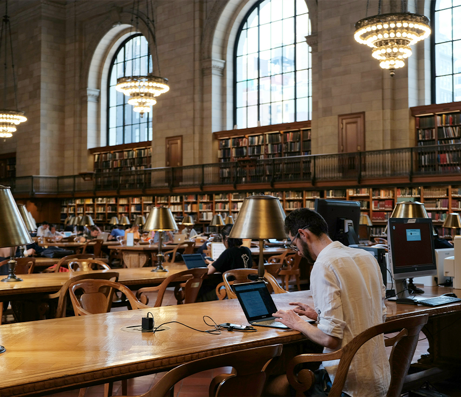 A person working on a laptop in a library