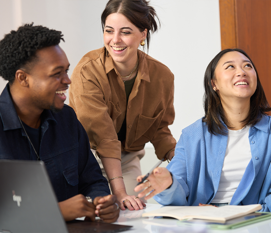 Three students smiling in a classroom