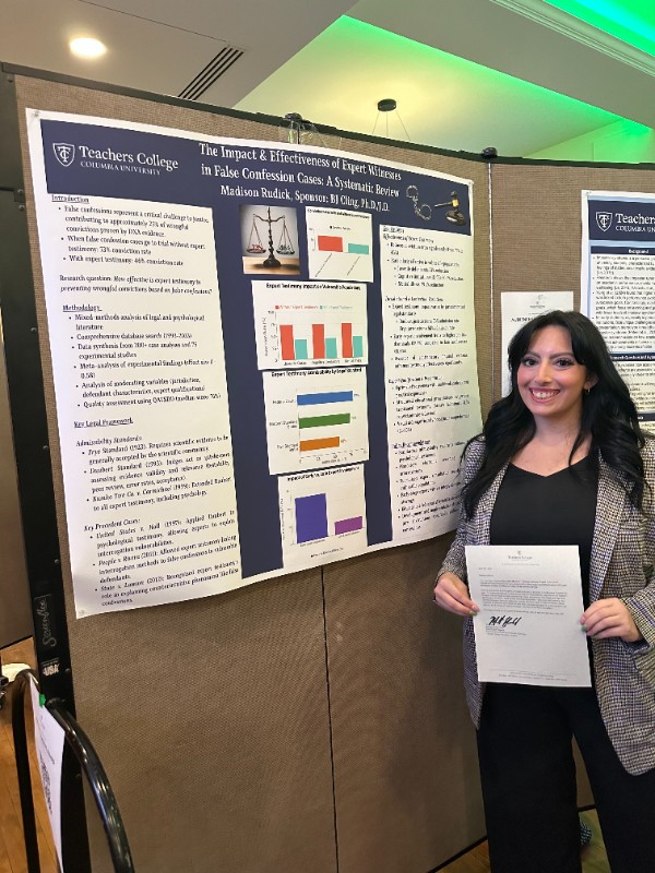 Student standing with project poster board