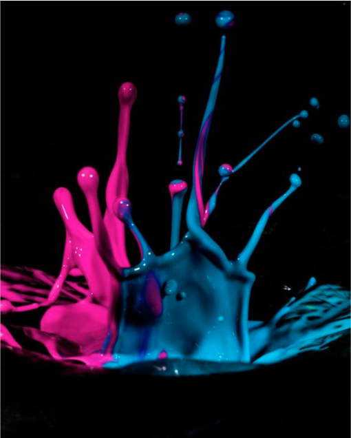 A splash of pink and blue paint on a black background