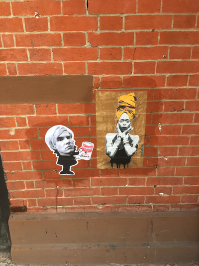 Erykah Badu image with yellow headwrap with other street art