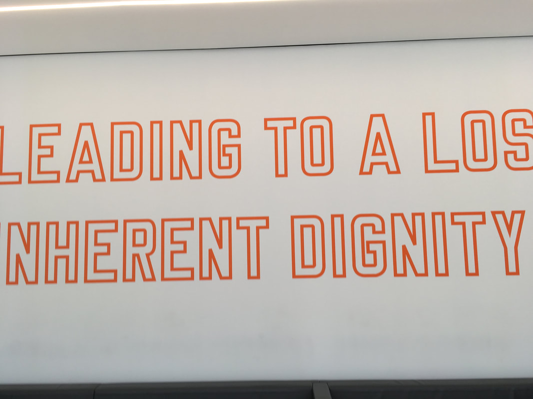 Neon orange lettering against white wall