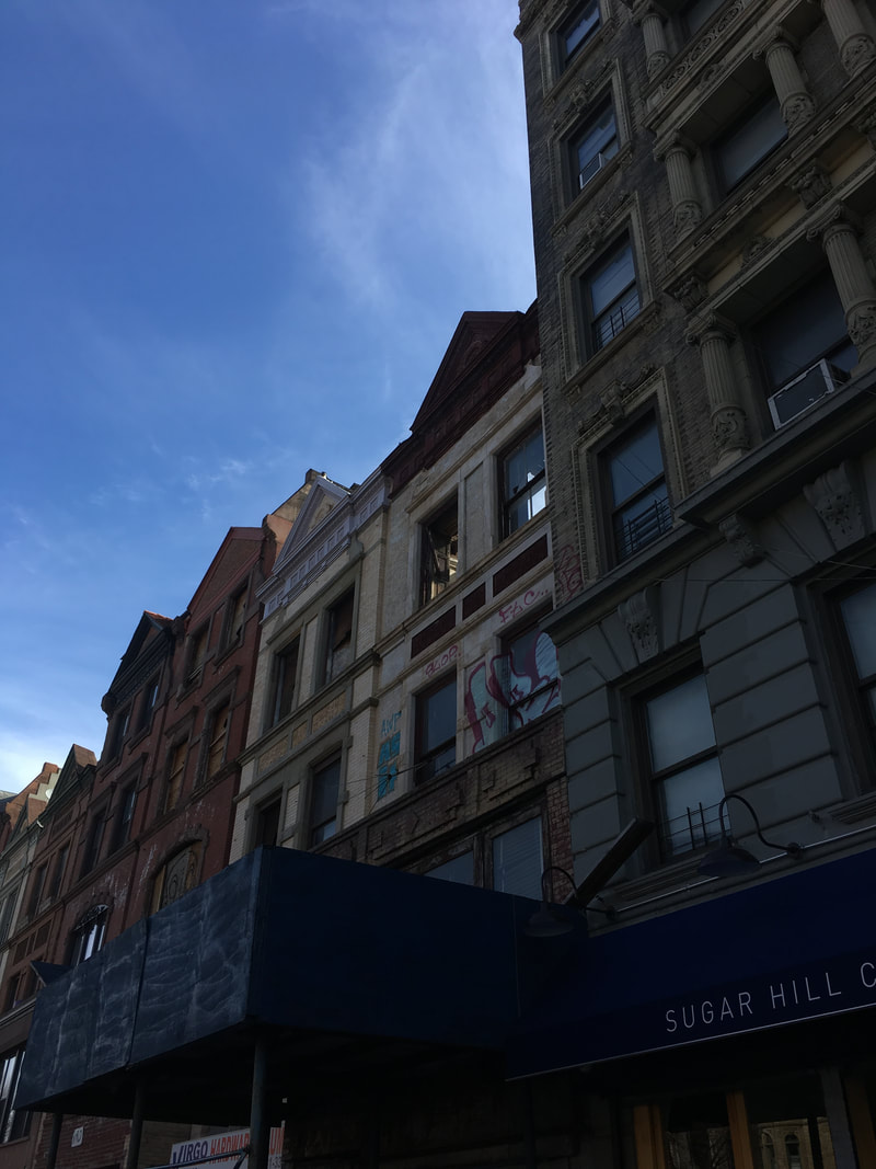 Buildings with a navy blue awning that says Sugar Hill