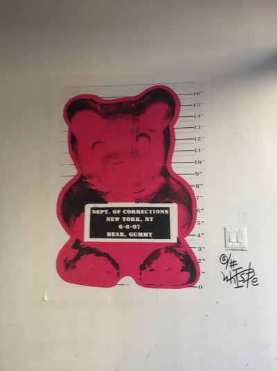 Gummy bear poster with an oversized pink gummy bear holding a sign