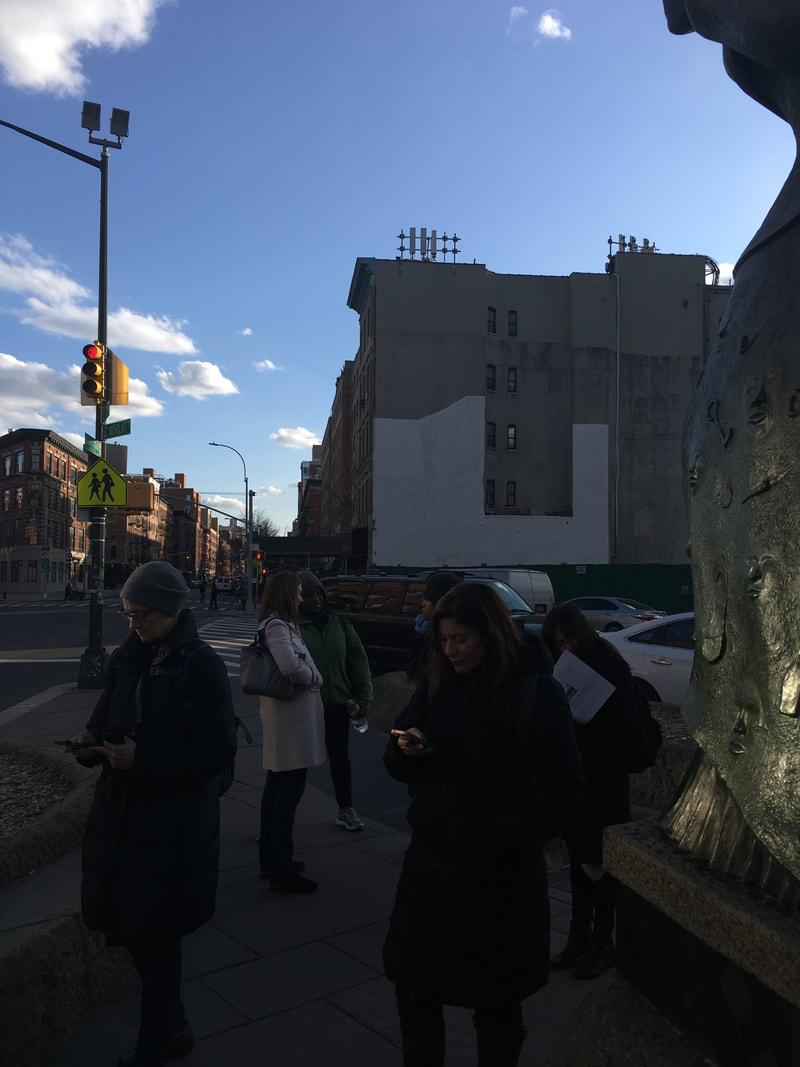 People walking on a sidewalk near concrete buildings