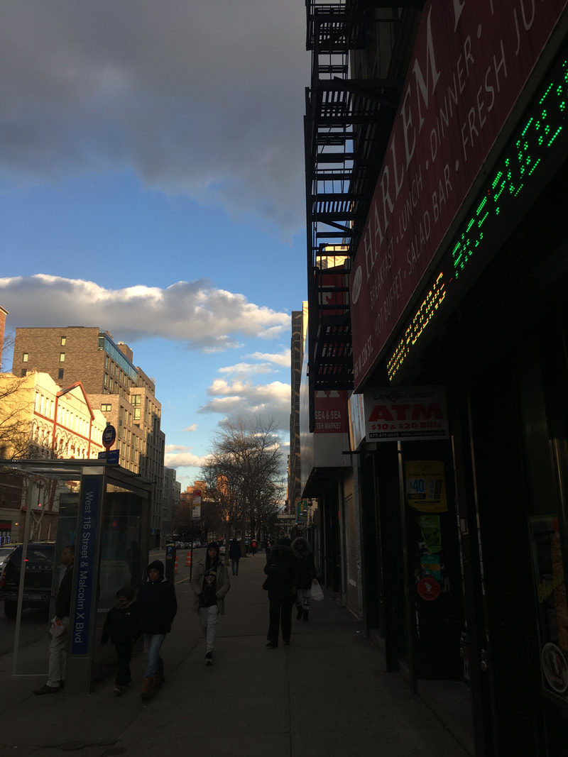 Bus stop on a busy sidewalk in front of a storefront