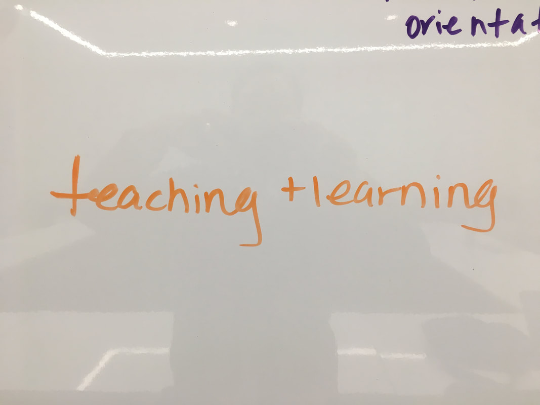 Teaching and learning written on a whiteboard in orange marker