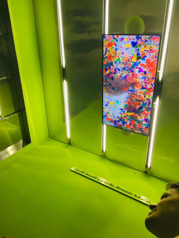 Looking up at colorful screen on elevator ceiling