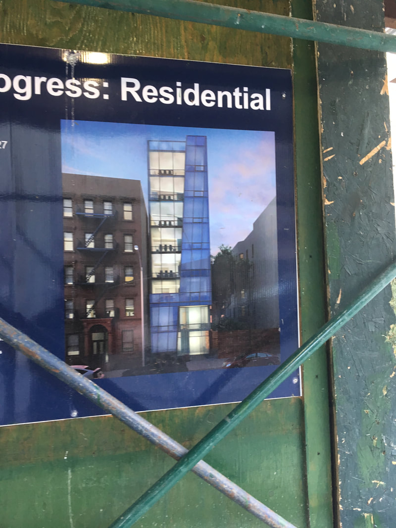 Black progress residential sign with white lettering on a glass window
