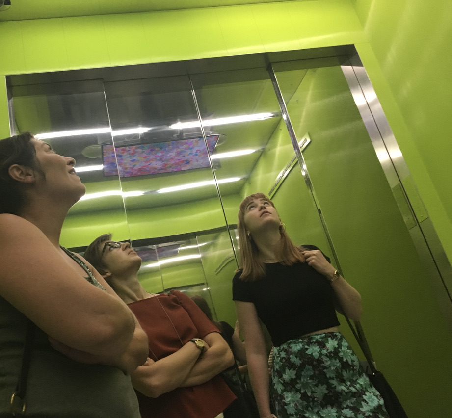 Three people looking up inside an elevator