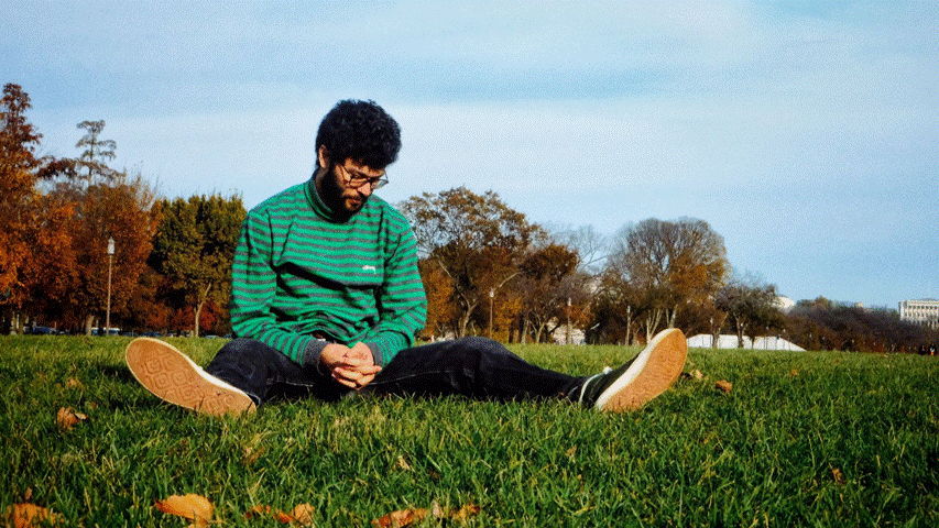 A gif alternates between Benjamin sitting on a lawn and kicking his legs up in the air.