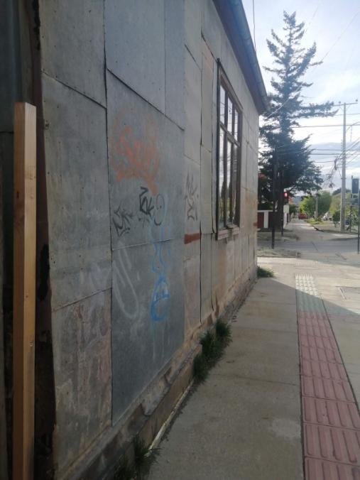 Side of building plated with tin sheets that have been graffitied.