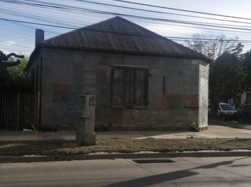 A large square stone structure with a tin roof. 