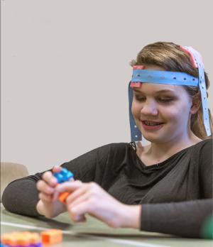 A participant wears a tDCS while working on motor training