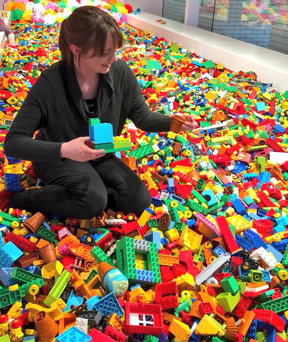 Kate Cowan sitting on a pile of Legos
