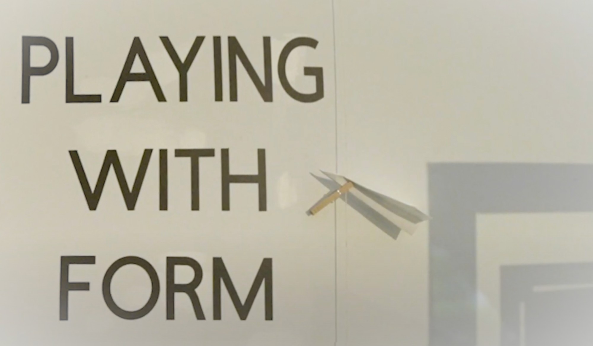 Title image of a wall with the words playing with form next to a paper airplane and shadow of a frame