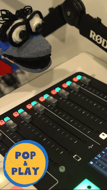 A sock puppet with large eyes and glasses turns up volume on an audio mixer with colorful lights