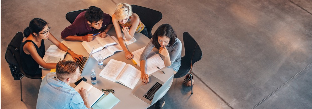Navigation image of students working collaboratively at circular table 