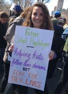 Elyse holding a large sign with colorful writing