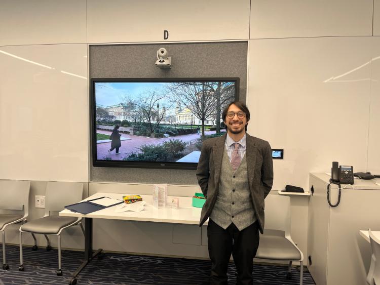 Image of anthropology student Fernando in front of his research display