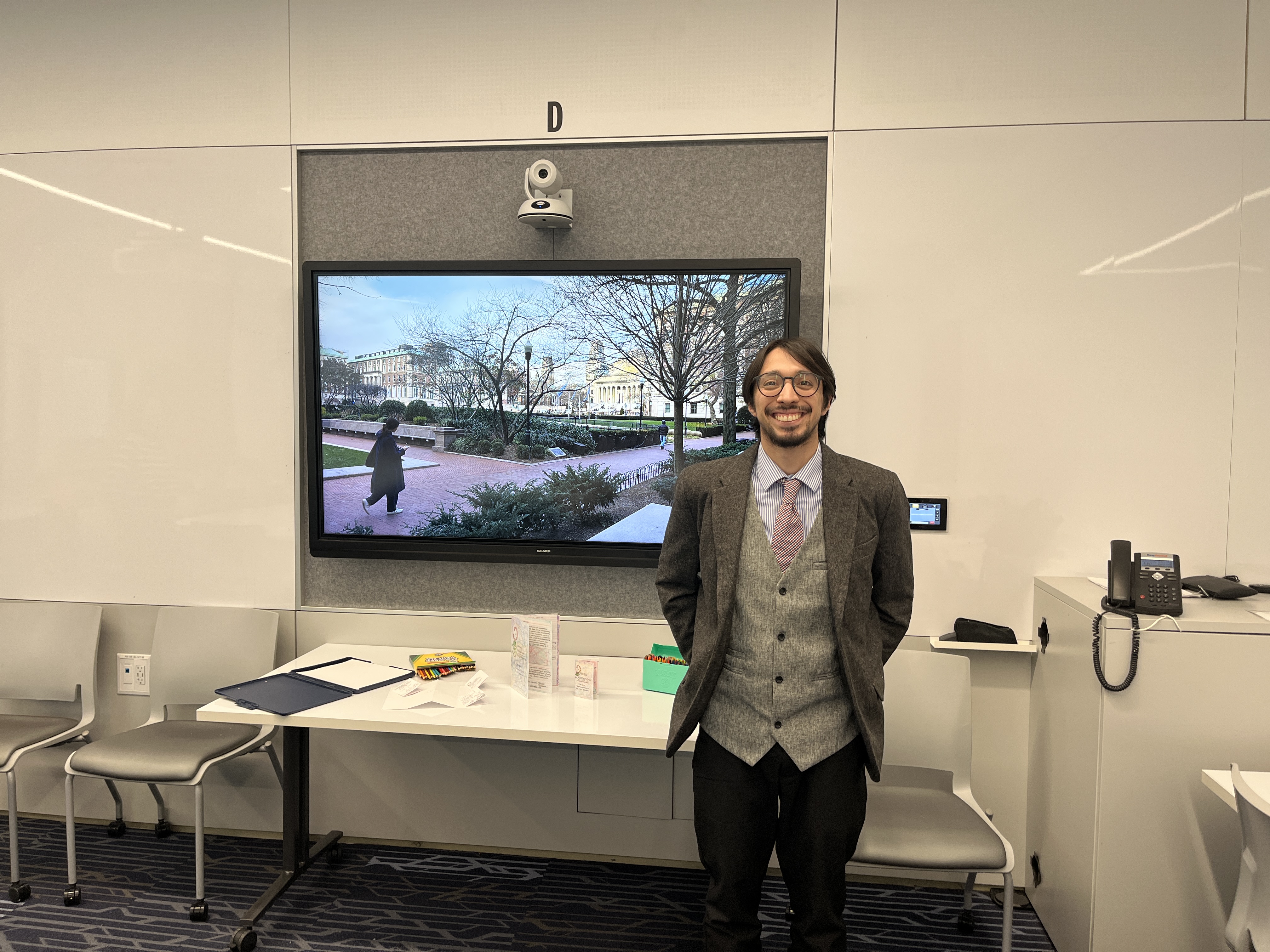 Image of anthropology student Fernando in front of his research display