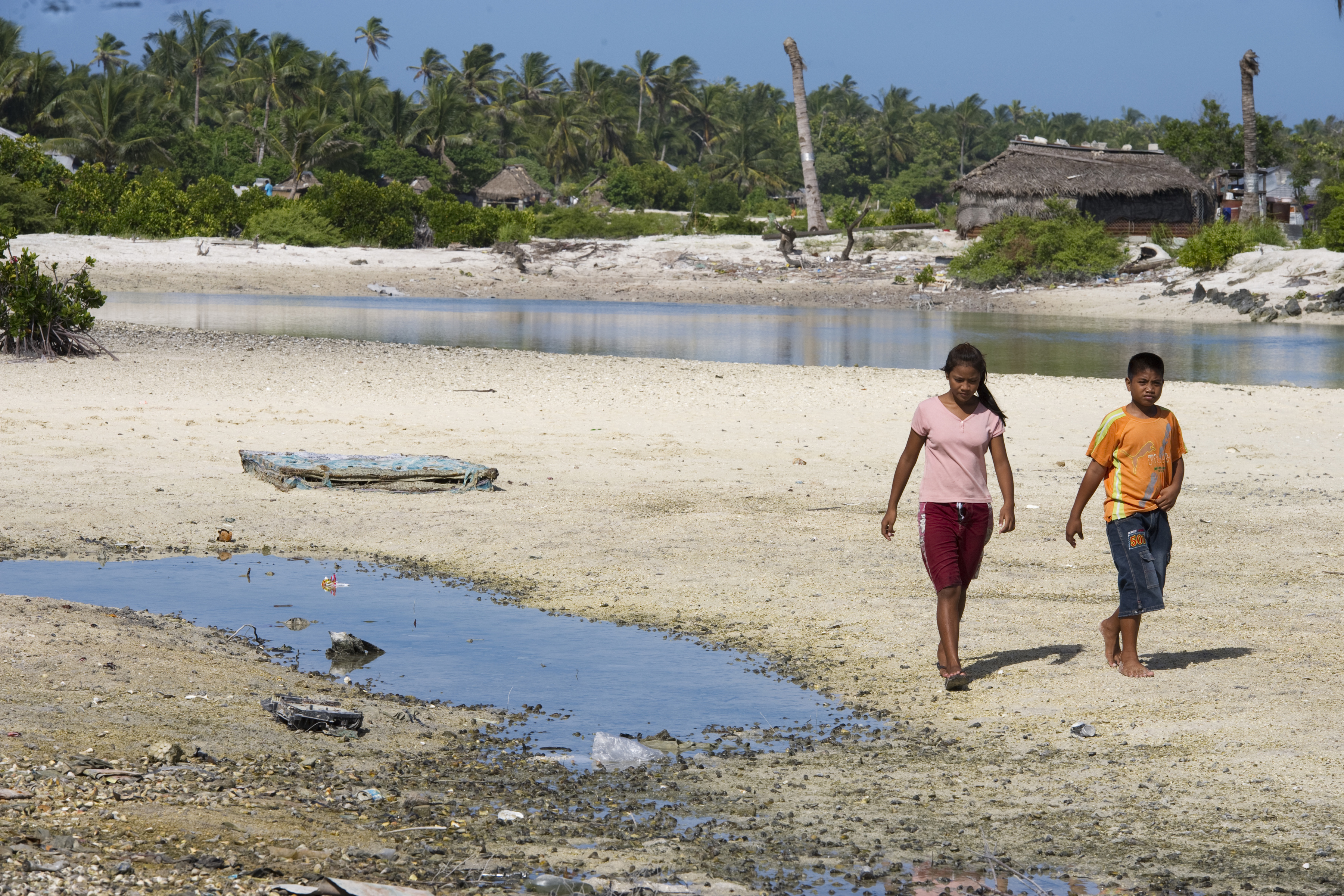 Two people walking on the Island Nation of Kiribati Affected by Climate Change