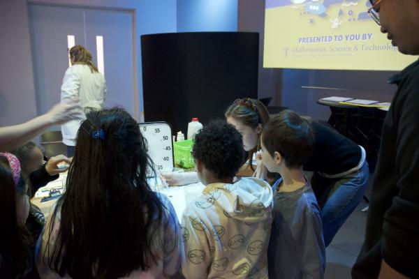 An image of students crowded around the Water Health station