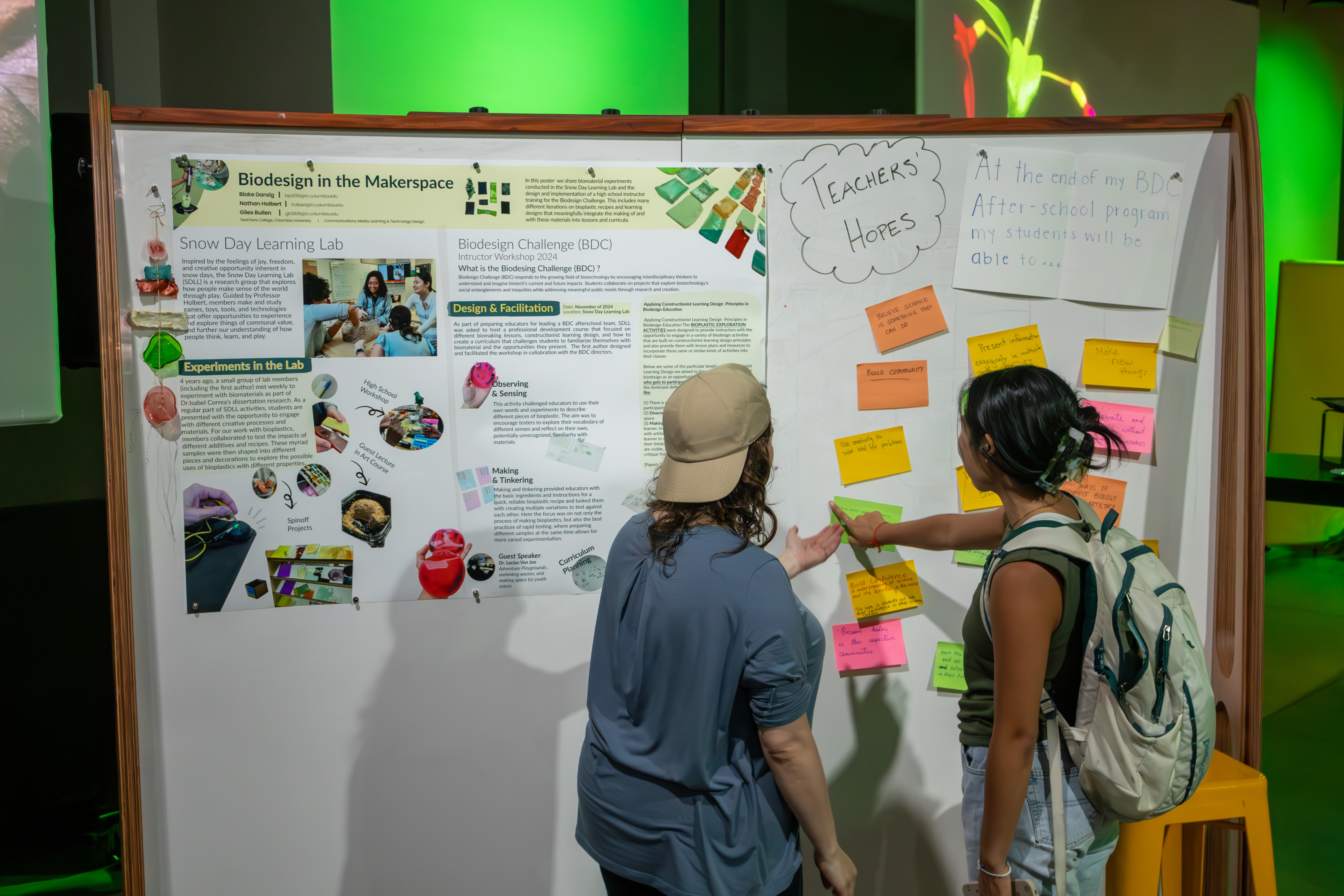 Two students talking in front of a poster presentation