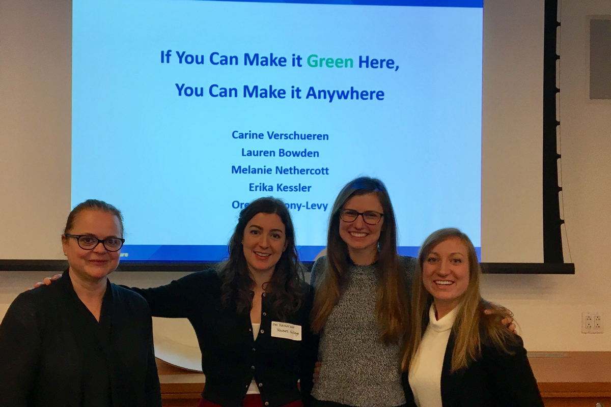 Students pose in front of their presentation on Sustainability