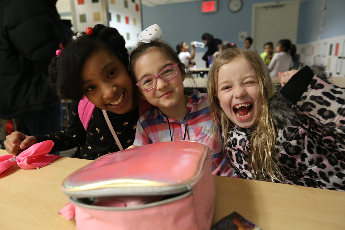 Three students smile at the camera at TCCS