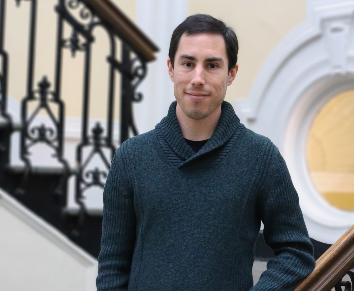 Man in blue sweater smiling at the camera